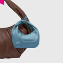 Greta Nano Silky als Taschenanhaenger an brauner Tasche befestigt

